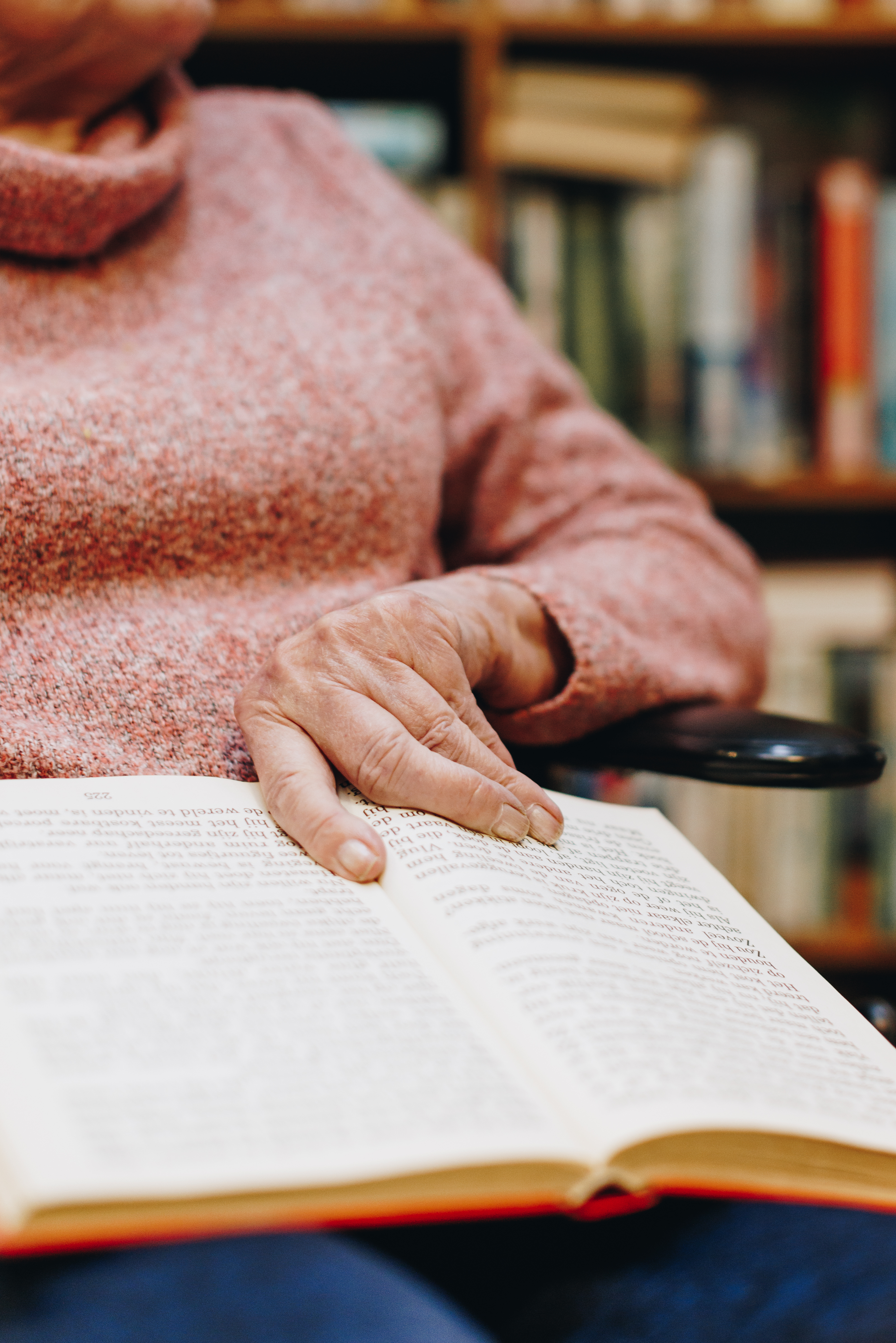 09 03 2023 Zorgpartners De Breeje Hendrick Bewoner Rolstoel Lezen Leeshoek Boeken Close Up Hand